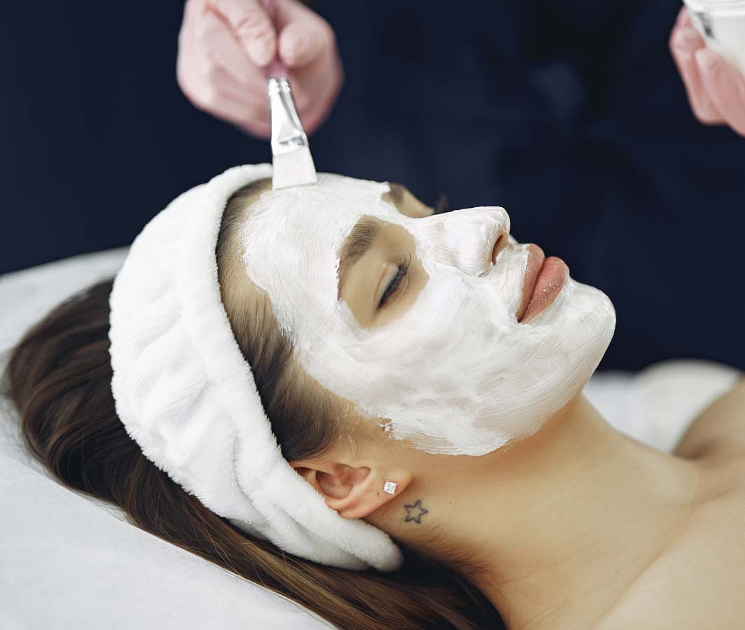Woman receiving facial peel at spa