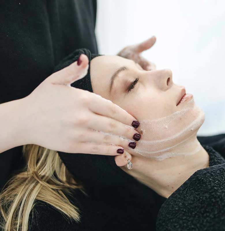 Woman getting skincare cleanser at day spa